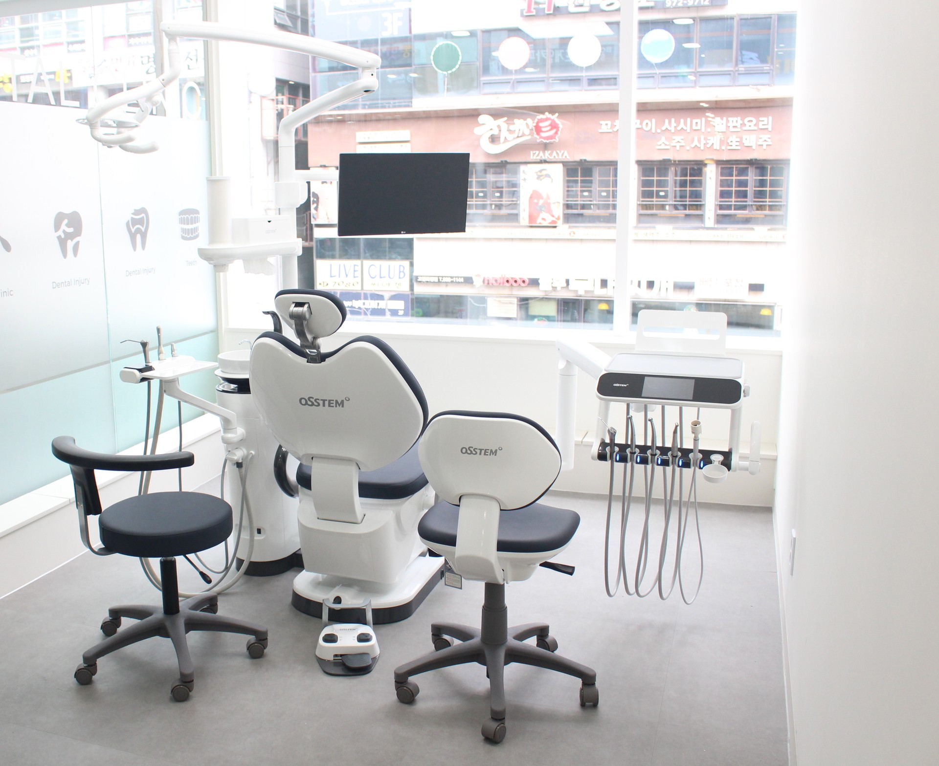 창가 진료실의 진료 의자와 벽걸이 모니터